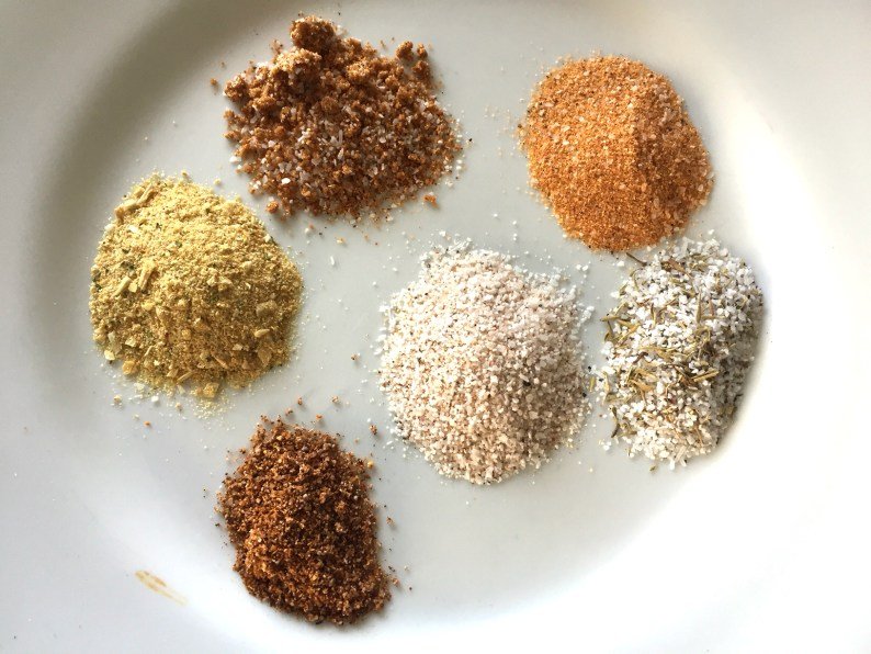 From top middle, clockwise: dried onion powder, pork rub, Savannah Rub, Perfect Roast Blend, Four Season Blend, Magic Dust